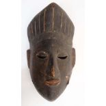 Ethnographica : A Native Tribal : an African Nigerian carved wooden tribal mask with traces of