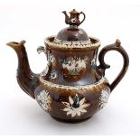 A 19thC large Bargeware / Measham teapot decorated with traditional design on a brown glazed body,