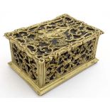 A late 19thC brass and cedar lined humidor with image to top of putti amongst Rococo brass ware 8"