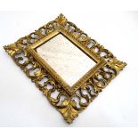 An 18thC / 19thC gilded Florentine carved wooden frame and mirror .