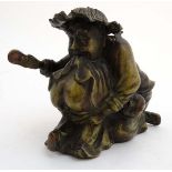 A cast bronze hollow figure of an elder reprimanding a young boy with a shoe.