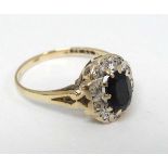 A 9ct gold ring set with central sapphire bordered by diamonds CONDITION: Please
