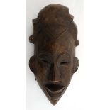 Ethnographica : A Native Tribal : an African carved wooden mask With twisted wire decoration ,