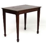 An Edwardian mahogany table with reeded tapering legs and spade feet 35 1/2" wide x 23 1/3" deep x