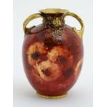A late 19thC Doulton Burslem two handled ' Chrysanthemum ' vase decorated with flowers on a ruby