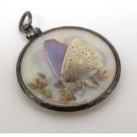 A double sidled glazed pendant locket with white metal mounts and mother of pearl centre with