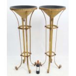 Mid Century / Hollywood Regency : a pair of floor standing torchieres with four feet and decorated