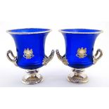 A pair of 21stC blue glass champagne buckets / wine coolers of compana urn form with silver plated