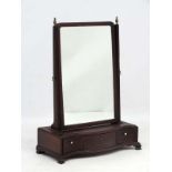 A Georgian mahogany serpentine tines shaped 3 drawer toilet mirror, on ogee feet.