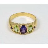 A silver gilt ring set with amethysts and peridot with four chip set diamonds.