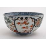 A Japanese ceramic bowl having floral decoration including flowering cherry blossom boughs in Imari