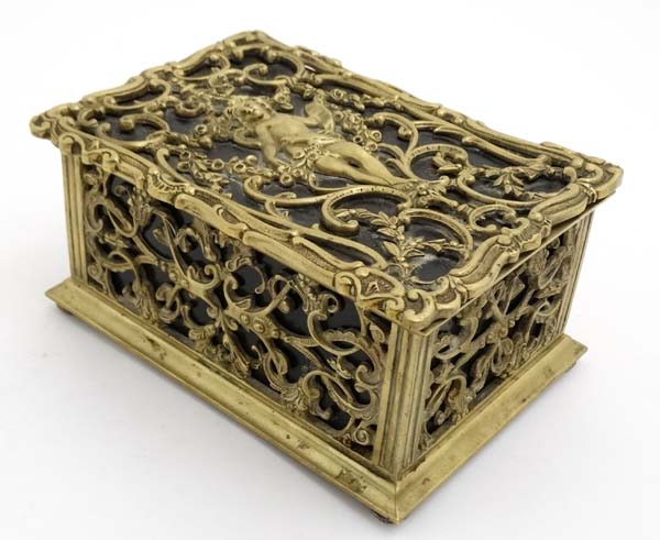 A late 19thC brass and cedar lined humidor with image to top of putti amongst Rococo brass ware 8" - Image 4 of 7