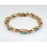 A gold bracelet set with turquoise cabochon.