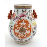 A Chinese famille rose two handled bailuzun vase decorated in polychrome enamels with Chinese luck