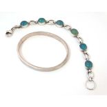 A silver bangle formed bracelet together with a silver bracelet set with opaque pale green cabochon.