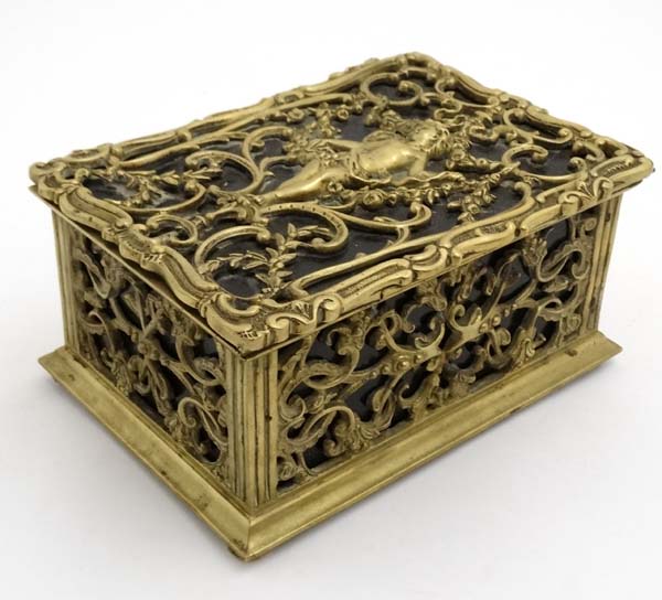 A late 19thC brass and cedar lined humidor with image to top of putti amongst Rococo brass ware 8" - Image 5 of 7