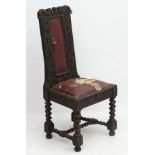 An early 18thC carved oak chair now with drop in seat and upholstered back splat with carved Fleur
