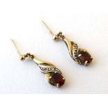 A pair of 9ct gold drop earrings set with garnets and chip set diamonds CONDITION: