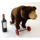 A c1920s '' Steiff '' straw filled pull-along plush bear with growler having amber coloured plastic