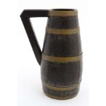 A wooden coopered and staved, brass bound jug / pitcher with wooden handle.
