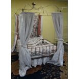 A Victorian brass and steel four-poster bed with ornate crown like top.