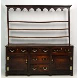 18 thC Oak Dresser : an open plate rack over a three top drawer and one over one central drawer