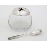 A novelty sauce pot the glass base with silver plated lid formed as an apple,