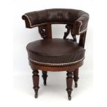 A 19thC walnut and leather swivel office / captains chair on four tuned legs with castors 30" high