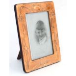 An Art Nouveau style easel / strut frame with embossed copper surround.