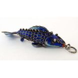 A white metal pendant / charm formed as an articulated fish with enamel decoration Approx. 2" long.
