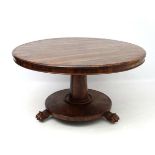 A rosewood circular tilt top table with circular column and three lions paw feet approx 51"