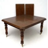 A Victorian mahogany extending dining table with 2 additional leaves,