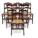 An American set of 6 faux Rosewood cane seated single chairs with carved decoration.