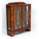 Art Deco : a Walnut veneered two door glazed display cabinet with glass tempered shelves.