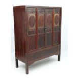 Chinese :a Chinese elm cabinet with painted and lacquered decoration the four doors opening to