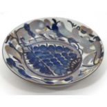 A Royal Copenhagen Faience dish of circular form decorated in shades of blue and grey on a white