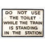 A 21stC painted cast metal sign "Do not use toilet whilst train in station".