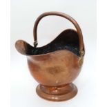 A late 19thC copper with brass handled helmet shaped coal scuttle 12 1/2" high