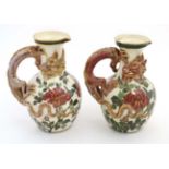 A pair of Continental jugs decorated in an Oriental style with 3 clawed dragon handles and