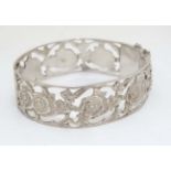 A Continental .800 silver bangle with open work floral decoration.