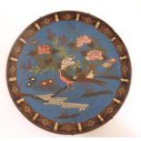 An Oriental Cloisonne charger depicting a pheasant amongst flowering foliage 9 1/2" diameter