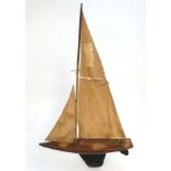 A large mid 20thC wooden sloop rigged pond yacht , named '' Storm Bird '' to side of hull,