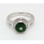 An 18ct gold ring set with central jade roundel bordered by diamonds CONDITION: