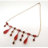 A gilt metal necklace set with facet cut pink/red stones. Approx.
