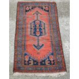 Carpet / Rug : A woollen rug with blue and red/pink ground with geometric arrow like motifs 81'' x