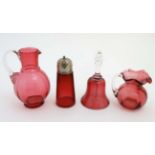 Cranberry Glass : a quantity of glass wares including 2 jugs, bell and a caster.