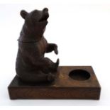 A 1928 Black Forest musical tobacco stand with carved bear decoration.