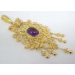 A silver gilt pendant set with amethyst cabochon to centre and a profusion of peridot and seed