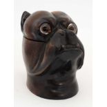 A late 20thC black forest tobacco jar formed as the head of a boxer dog with brass eyes and brass