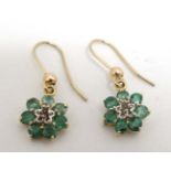 A pair of yellow metal drop earrings set with emeralds.